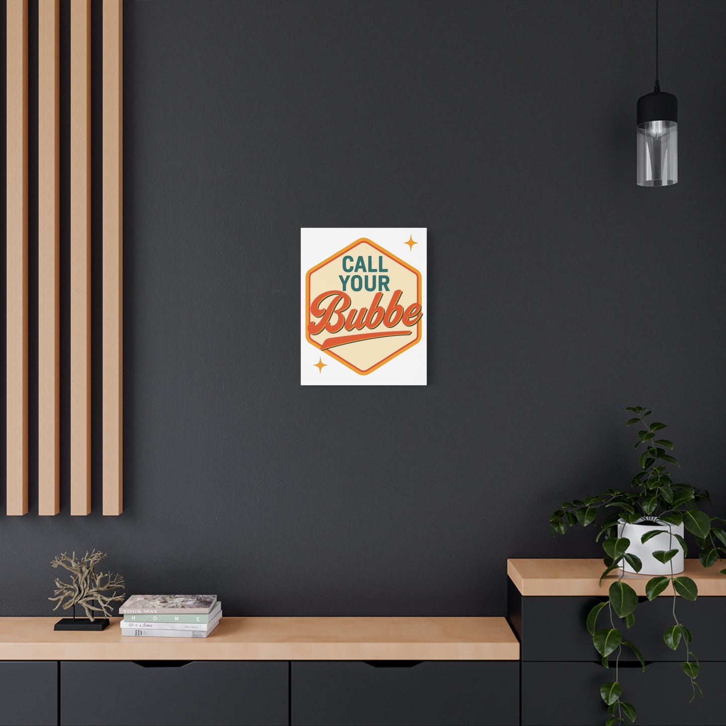 Poster with 'Call Your Bubbe' design on a dark wall above a wooden shelf.