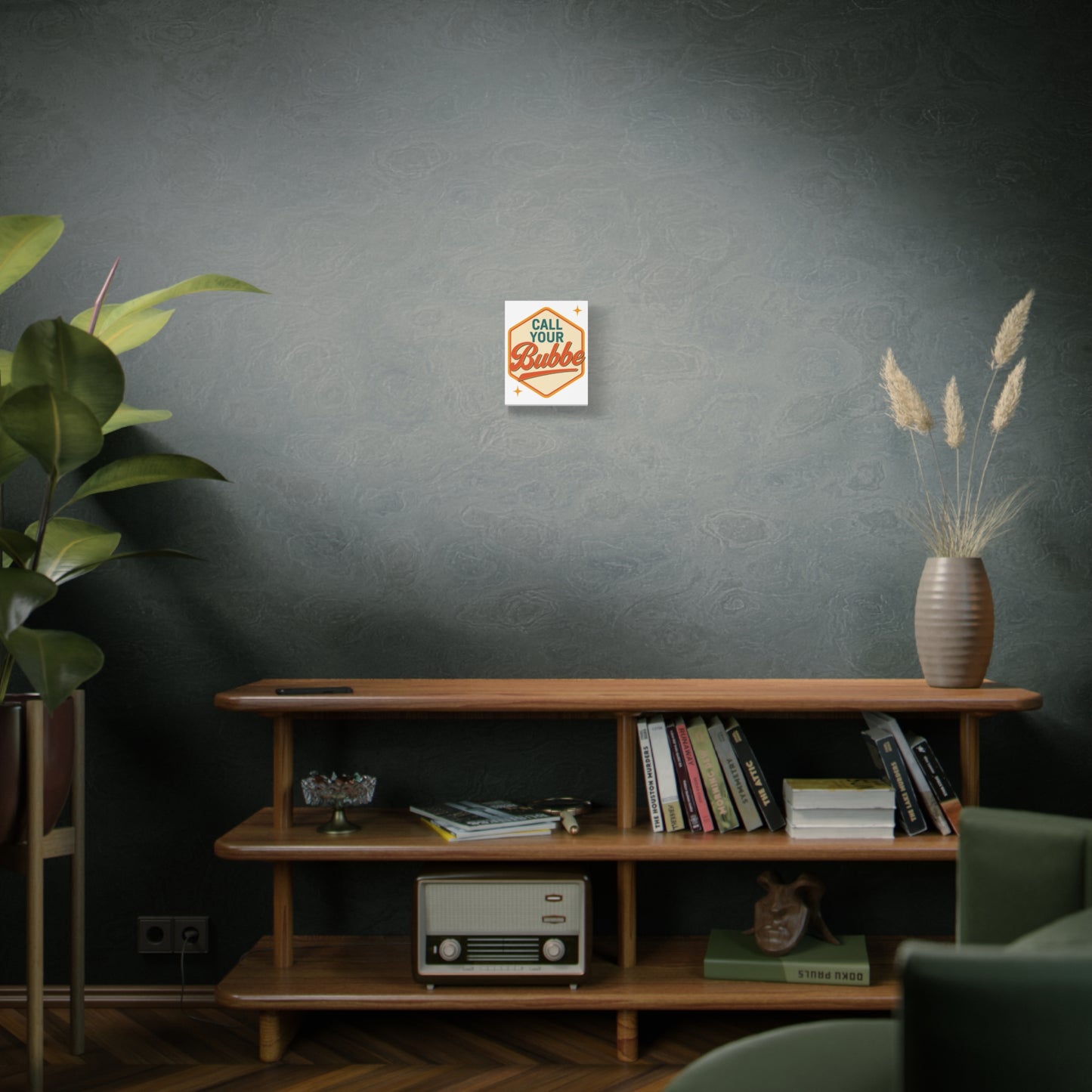 Modern living room with a wooden shelf, books, a plant, and a decorative 'call your bubbe' print on the wall.