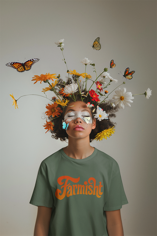 Person with flowers and butterflies on head, wearing a green 'Farmish' t-shirt against a plain background