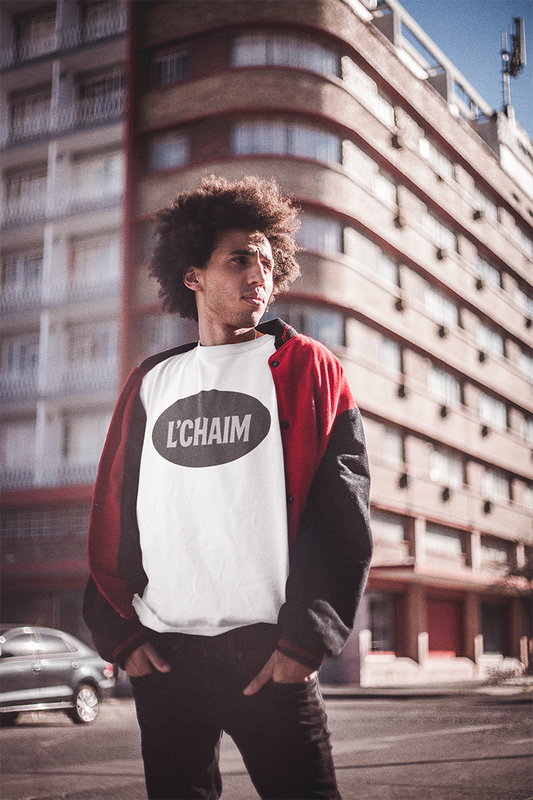 Person wearing a red, white, and black jacket with 'L'Chaim' logo in an urban setting