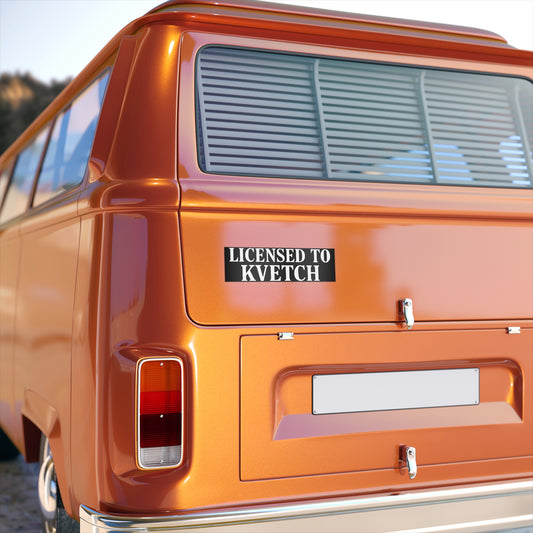 Orange van with a 'Licensed to Kvetch' sticker on the back