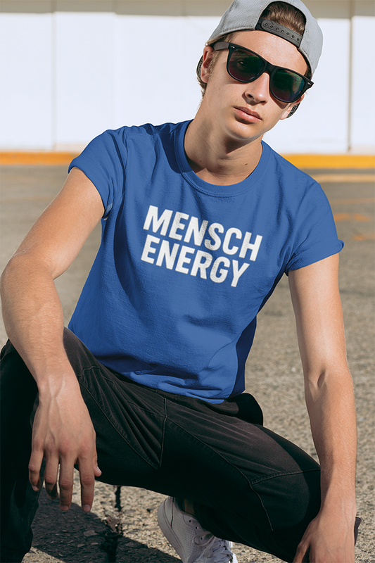 Person wearing a blue 'MENSCH ENERGY' t-shirt sitting outdoors.