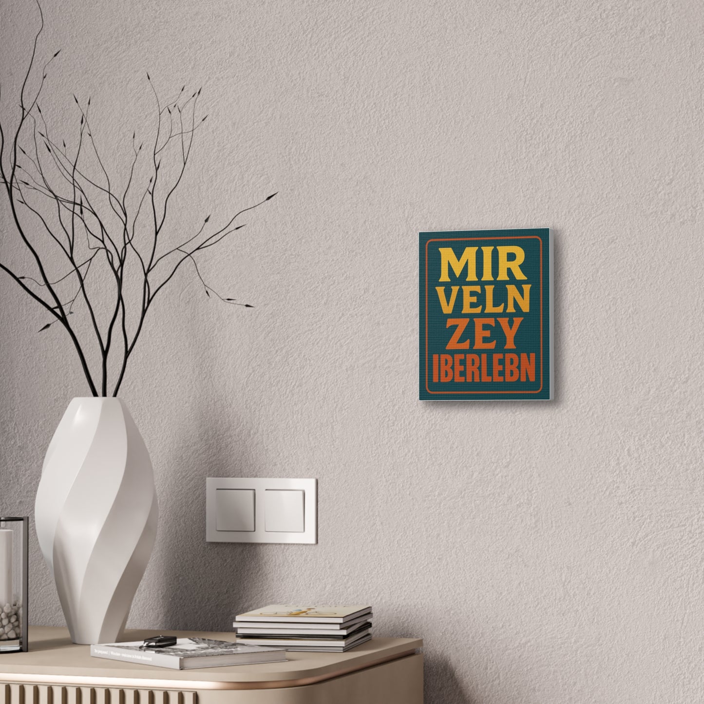 Decorative wall art with text on a light gray wall above a white vase and books.