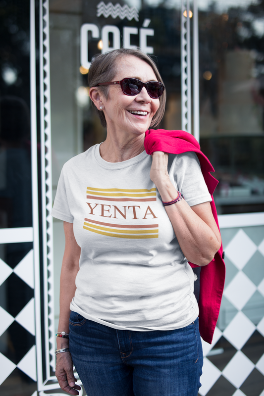 Woman wearing a 'YENTA' t-shirt in front of a coffee shop.