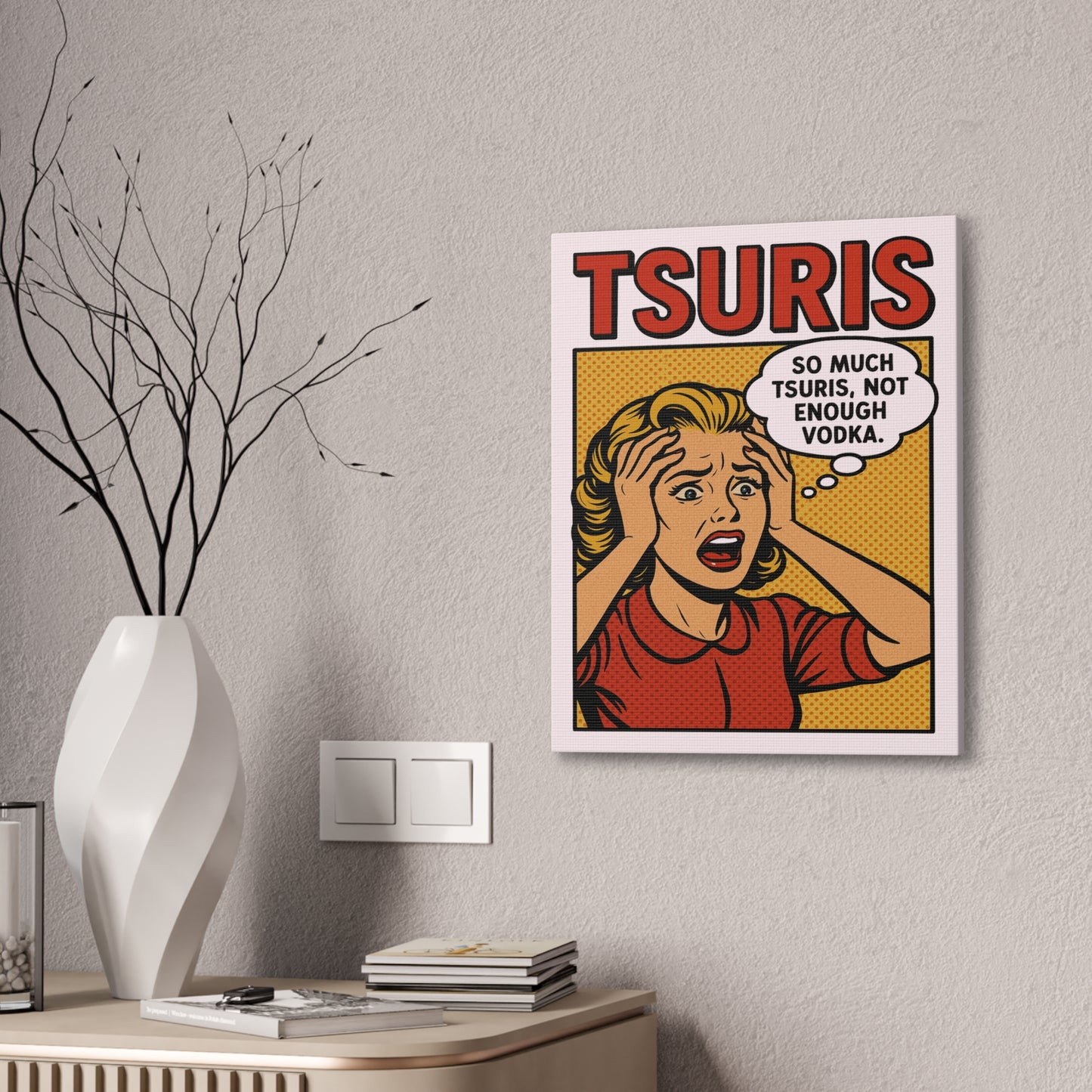 Framed artwork with a comic-style character and text on a wall above a table with decor items.