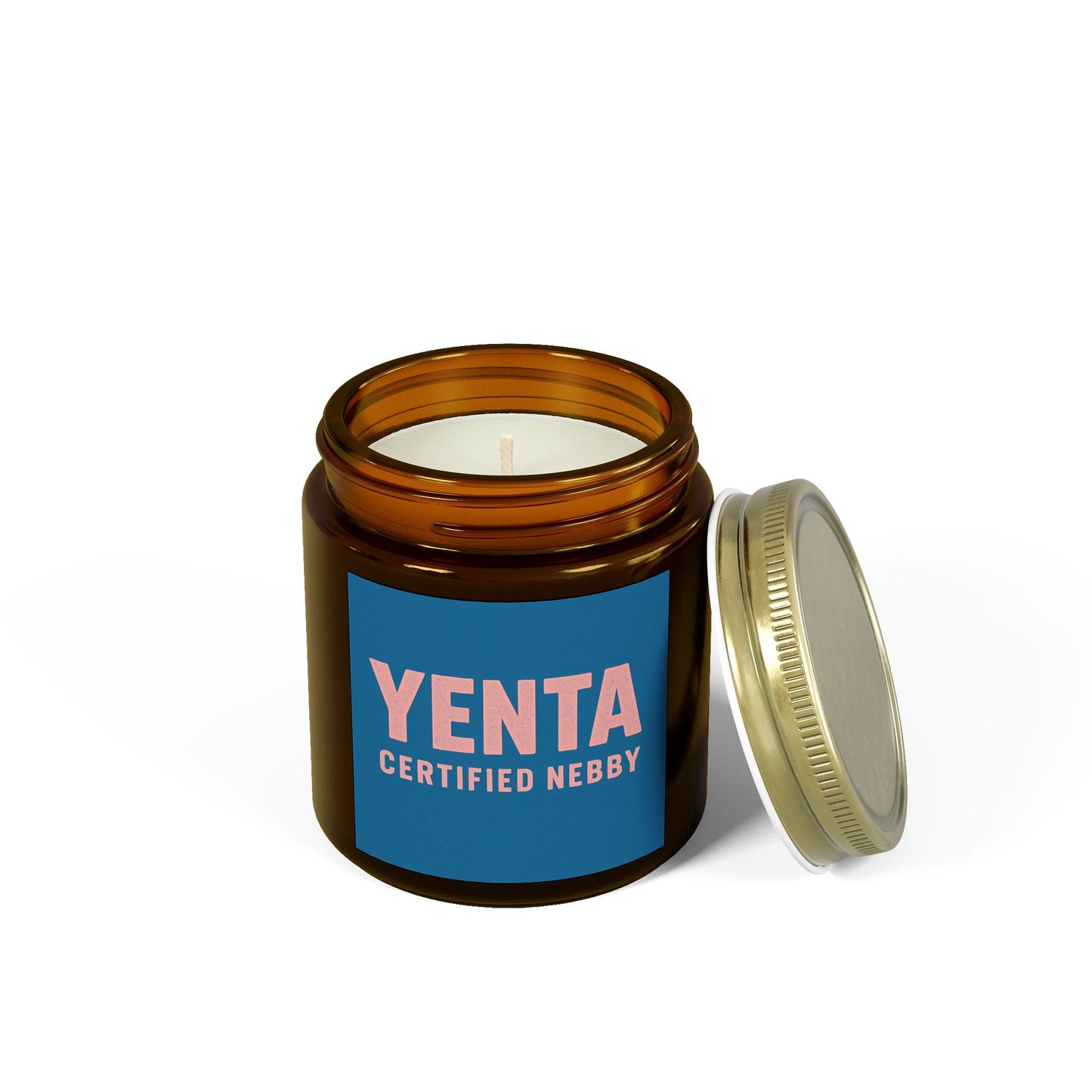 Candle in an amber jar with a blue label featuring 'Yenta Certified Nebby' on a white background.