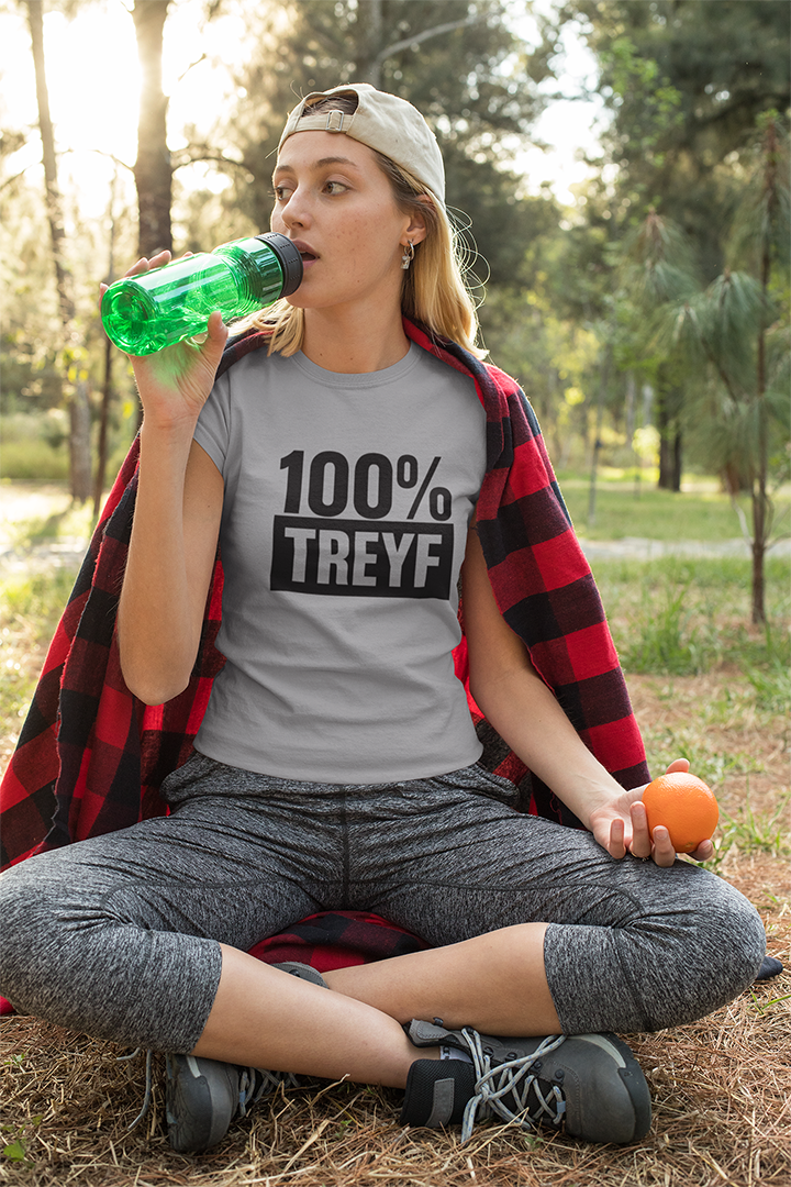 Person wearing a '100% Treyf' t-shirt sitting outdoors.
