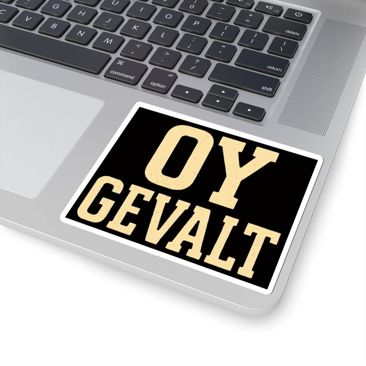 Laptop with a sticker reading 'OY GEVALT' on the palm rest area.