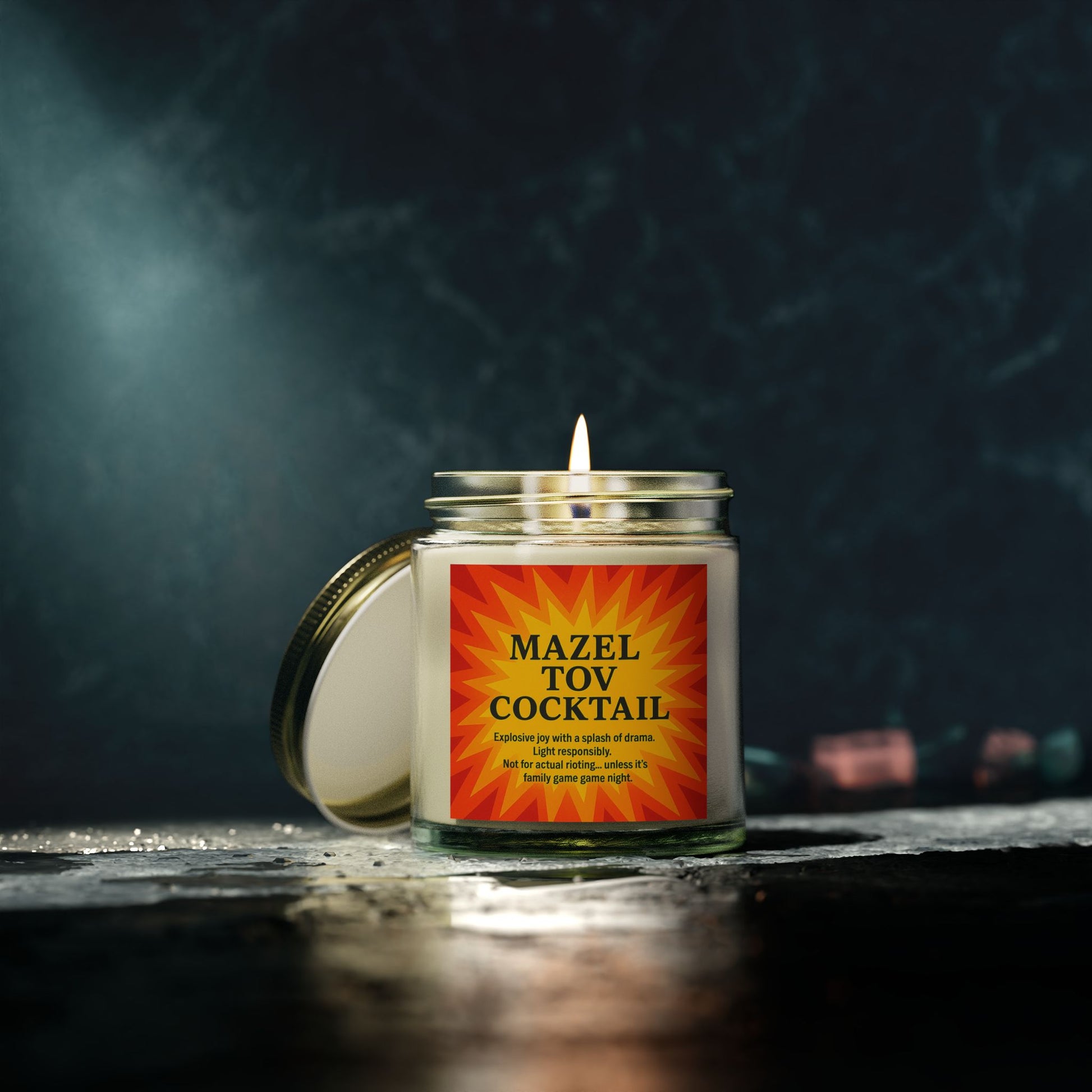 Candle in a jar with a 'Mazel Tov Cocktail' label on a dark background