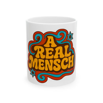 White mug with colorful text 'A REAL MENSCH' featuring stars on a white background