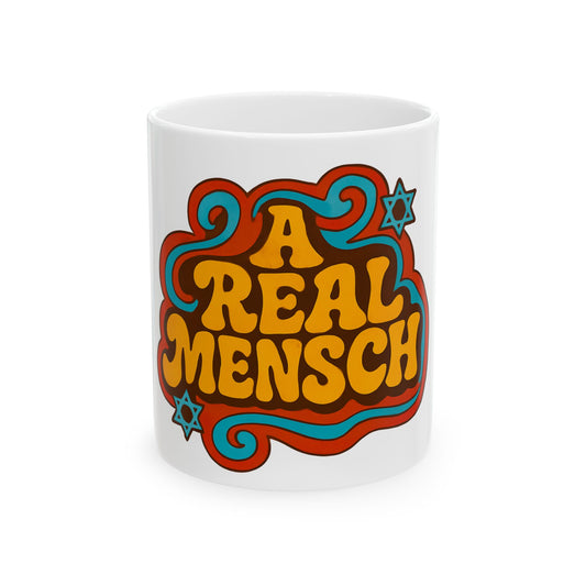 White mug with colorful text 'A REAL MENSCH' featuring stars on a white background
