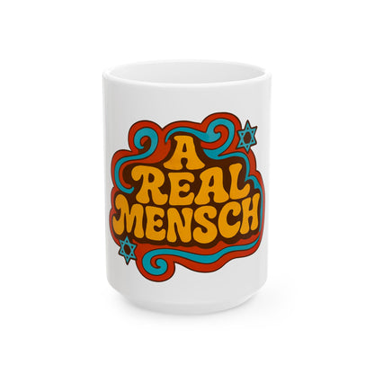 White mug with colorful 'A Real Mensch' design on a white background