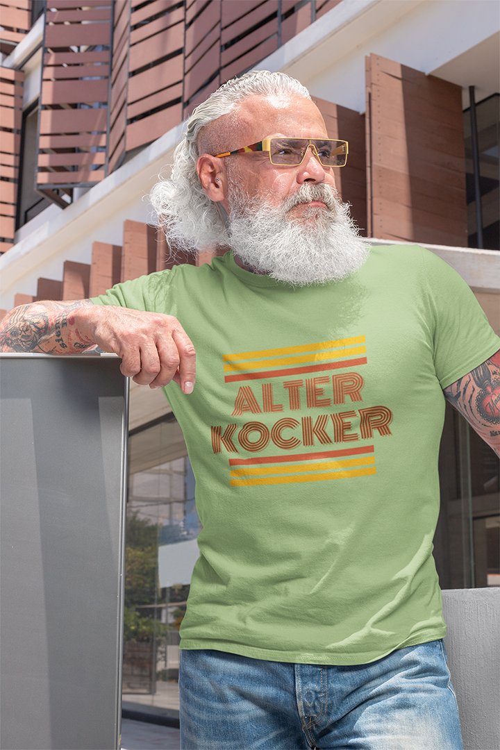 Man wearing a green t-shirt with 'ALTER KOCKER' text, standing outdoors.