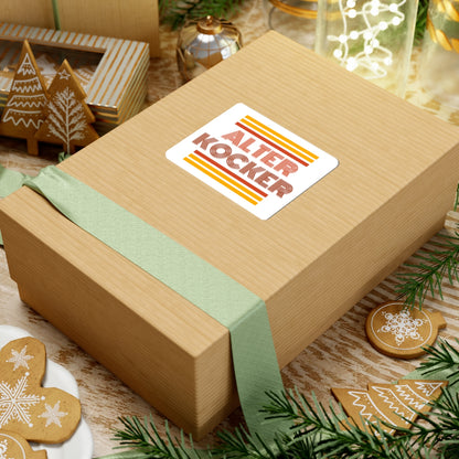 Wooden gift box with a 'Alter Kocker' label on a festive background with cookies and greenery.