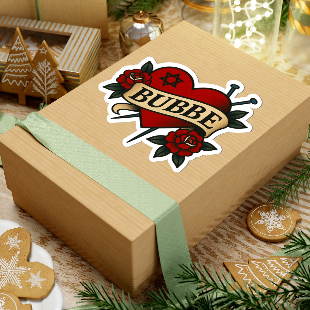 Wooden gift box with a 'Bubbe' sticker on a festive background with cookies and lights.