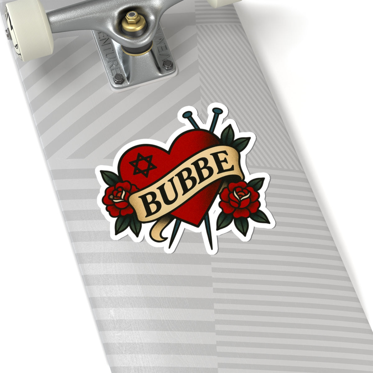 Skateboard with a 'Bubbe' heart-shaped tattoo design sticker on a white background