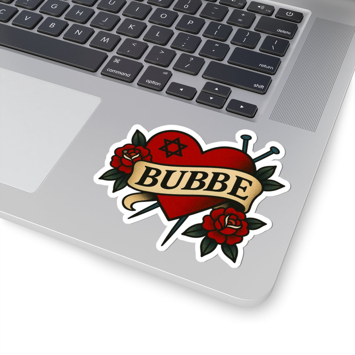 Laptop with a 'BUBBE' tattoo-style sticker featuring roses and a star of David.