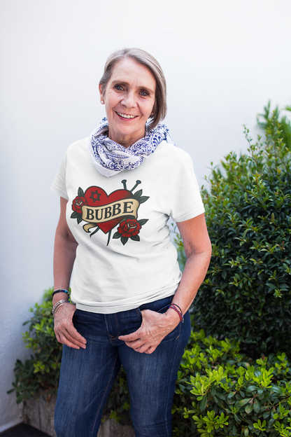 Woman wearing a white t-shirt with a graphic design and text, standing outdoors.
