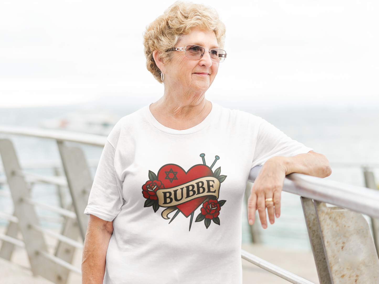 Woman wearing a white t-shirt with 'Bubbe' design, standing outdoors.