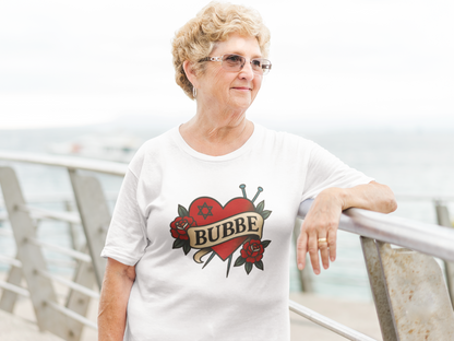 Woman wearing a white t-shirt with 'Bubbe' design, standing outdoors.