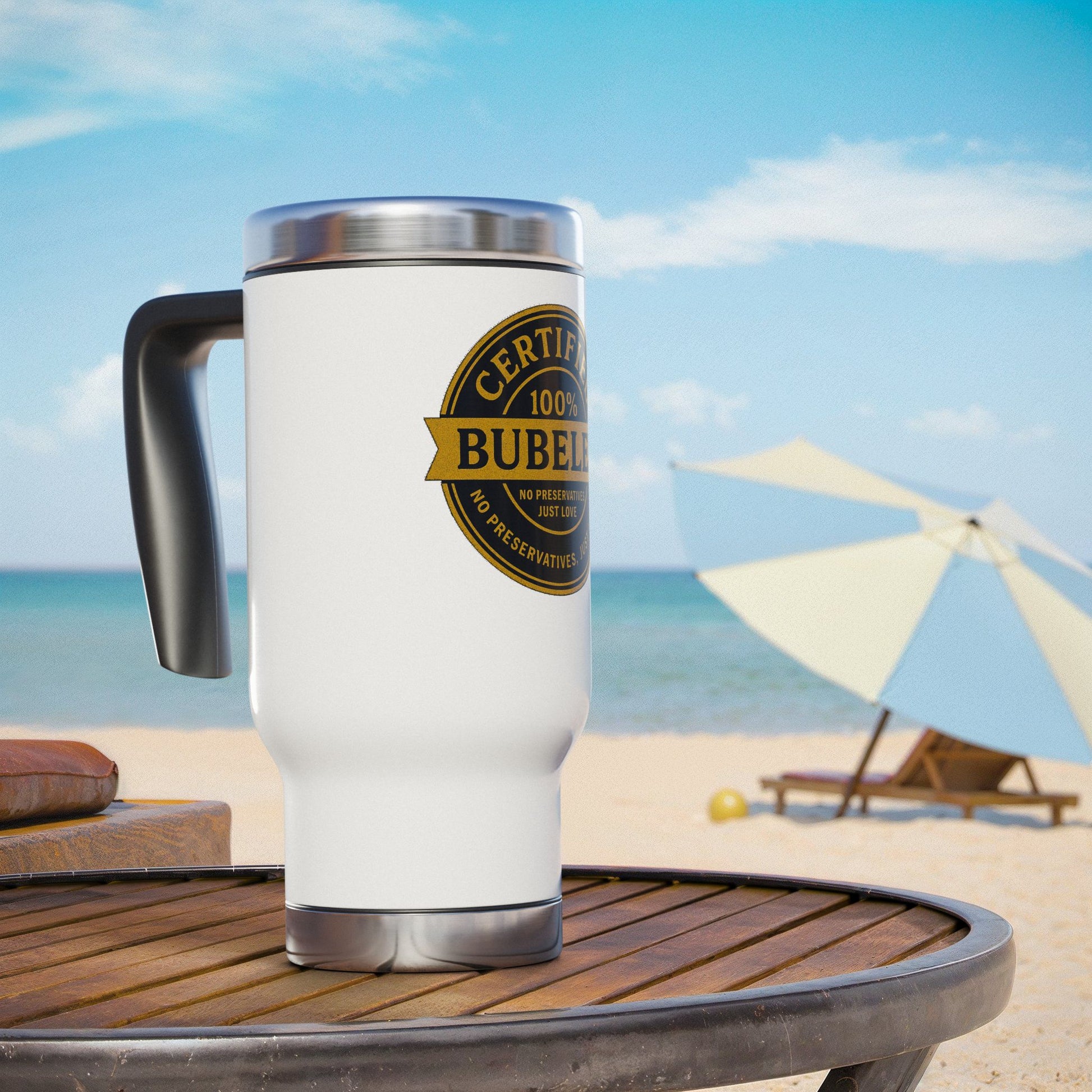 White travel mug with a 'Certified Bubeleh' design on a beach setting