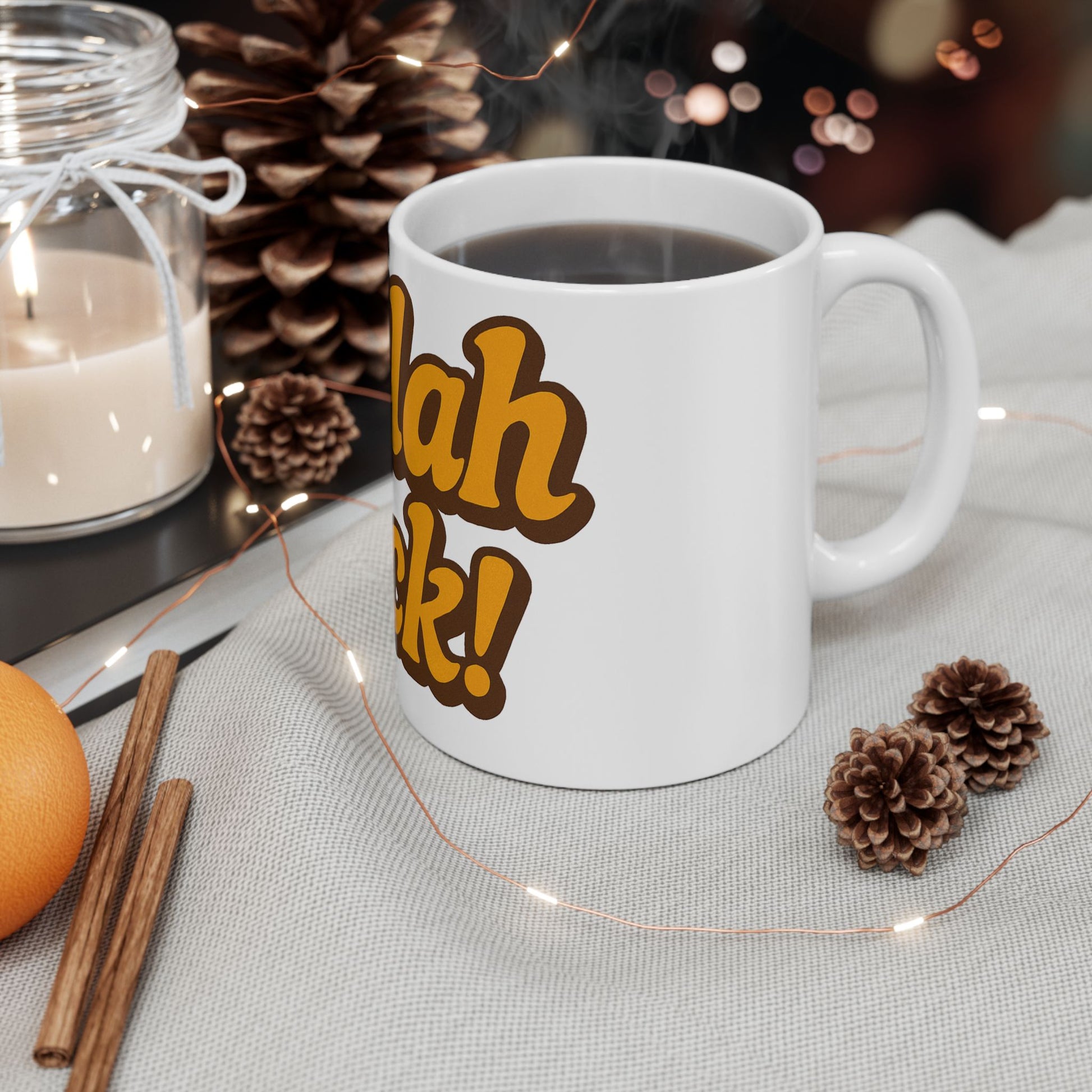 White mug with Challah Back!' text on a table with decorative items like pine cones and an orange.