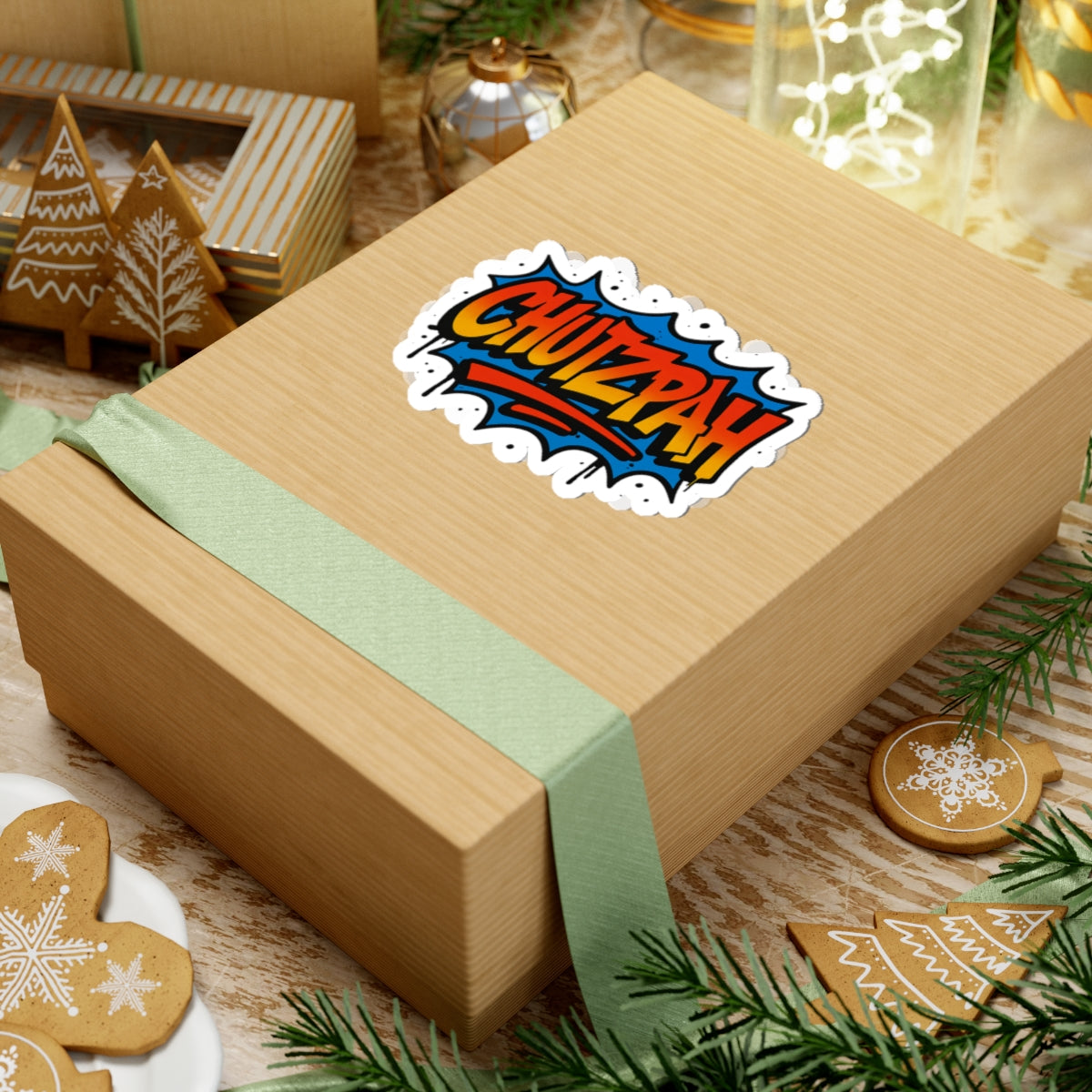 Wooden gift box with a colorful 'CHUTZPAH' sticker on a festive background with cookies and greenery.