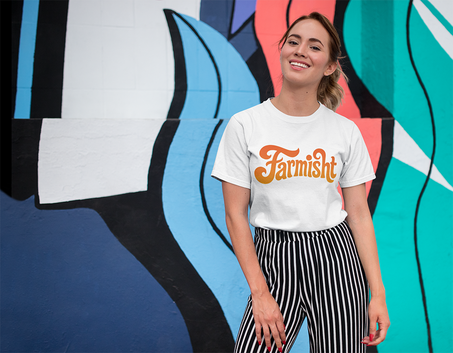 Person wearing a white t-shirt with 'Farmish' logo in front of a colorful mural.