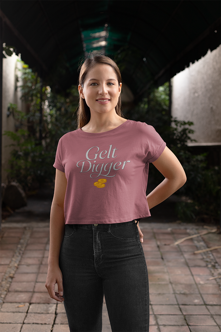 Woman wearing a pink t-shirt with 'Gelt Digger' text and a yellow duck graphic, standing outdoors.