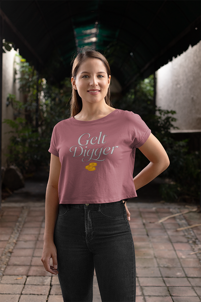 Woman wearing a pink t-shirt with 'Gelt Digger' text and a yellow duck graphic, standing outdoors.
