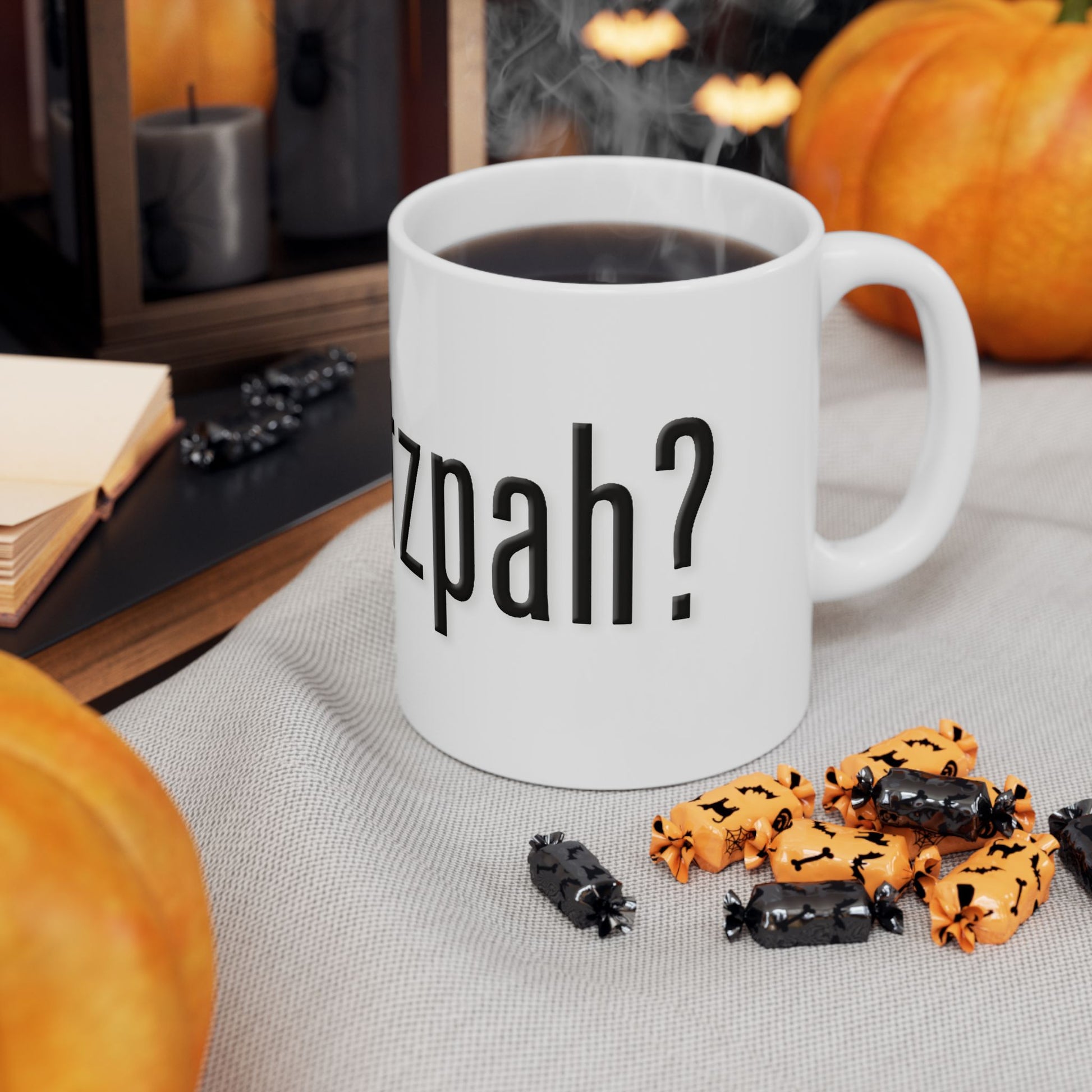 White mug with 'got chutzpah?' text, surrounded by Halloween-themed treats and pumpkins.