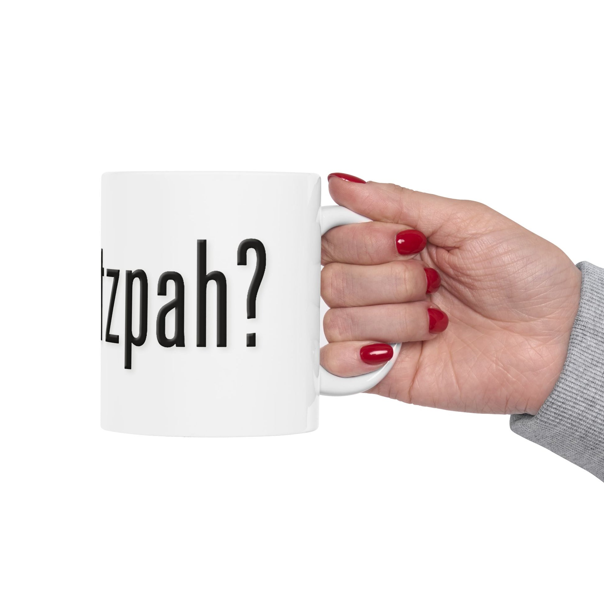 Hand holding a white mug with 'got chutzpah?' printed on it against a white background