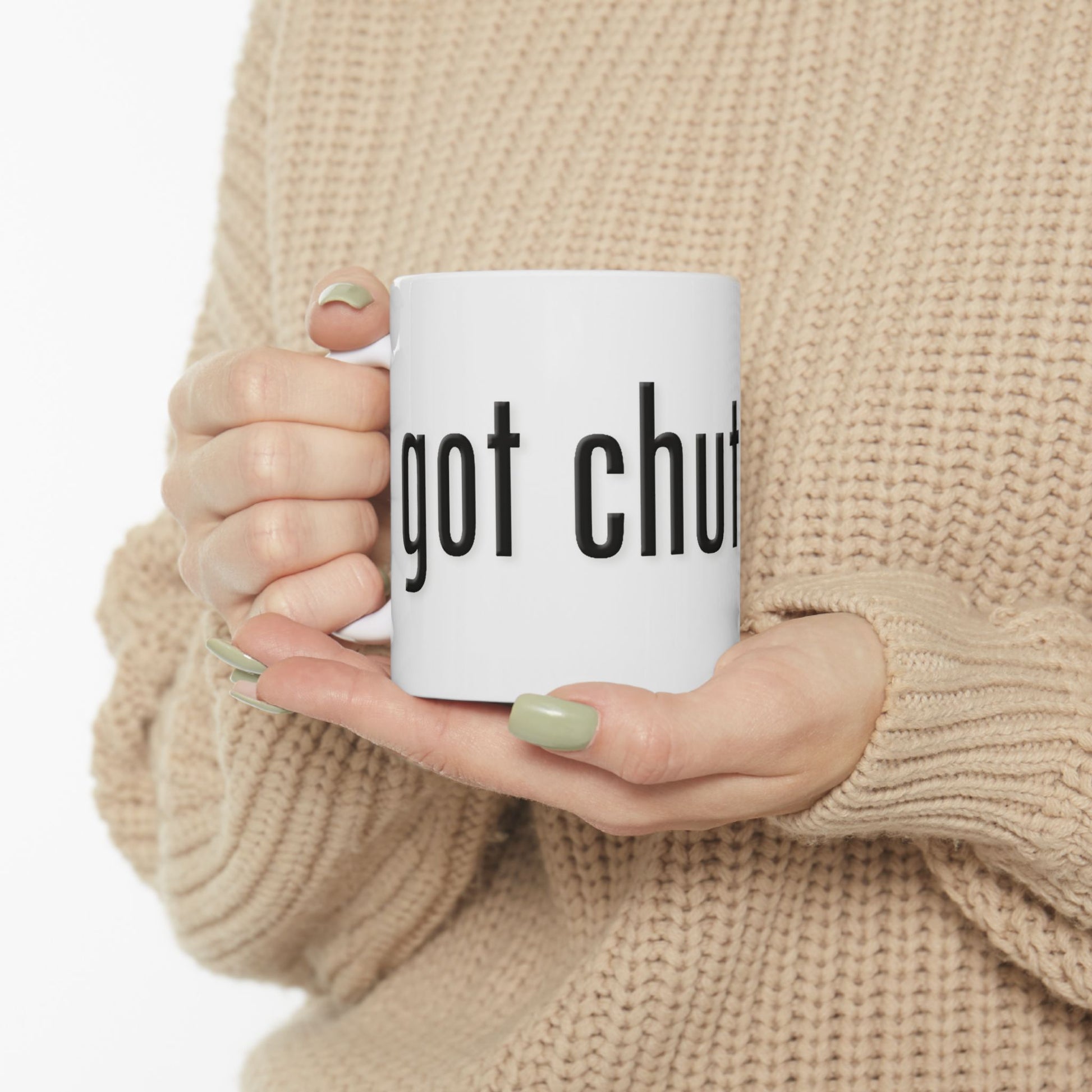 Person holding a mug with 'got chutzpah?' text, wearing a beige sweater.