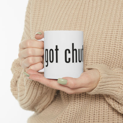 Person holding a mug with 'got chutzpah?' text, wearing a beige sweater.