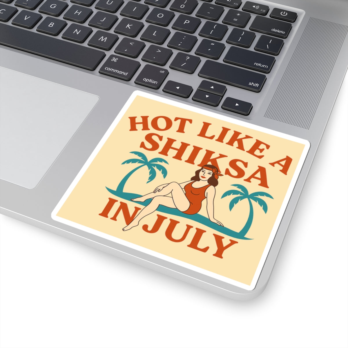Laptop with a decorative sticker reading 'Hot like a shiksa in July' on the palm rest area.