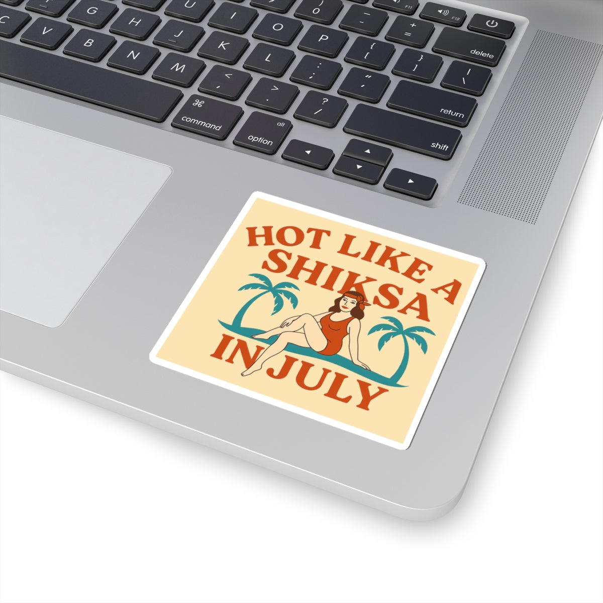 Sticker with text 'Hot like a shiksa in July' on a laptop keyboard