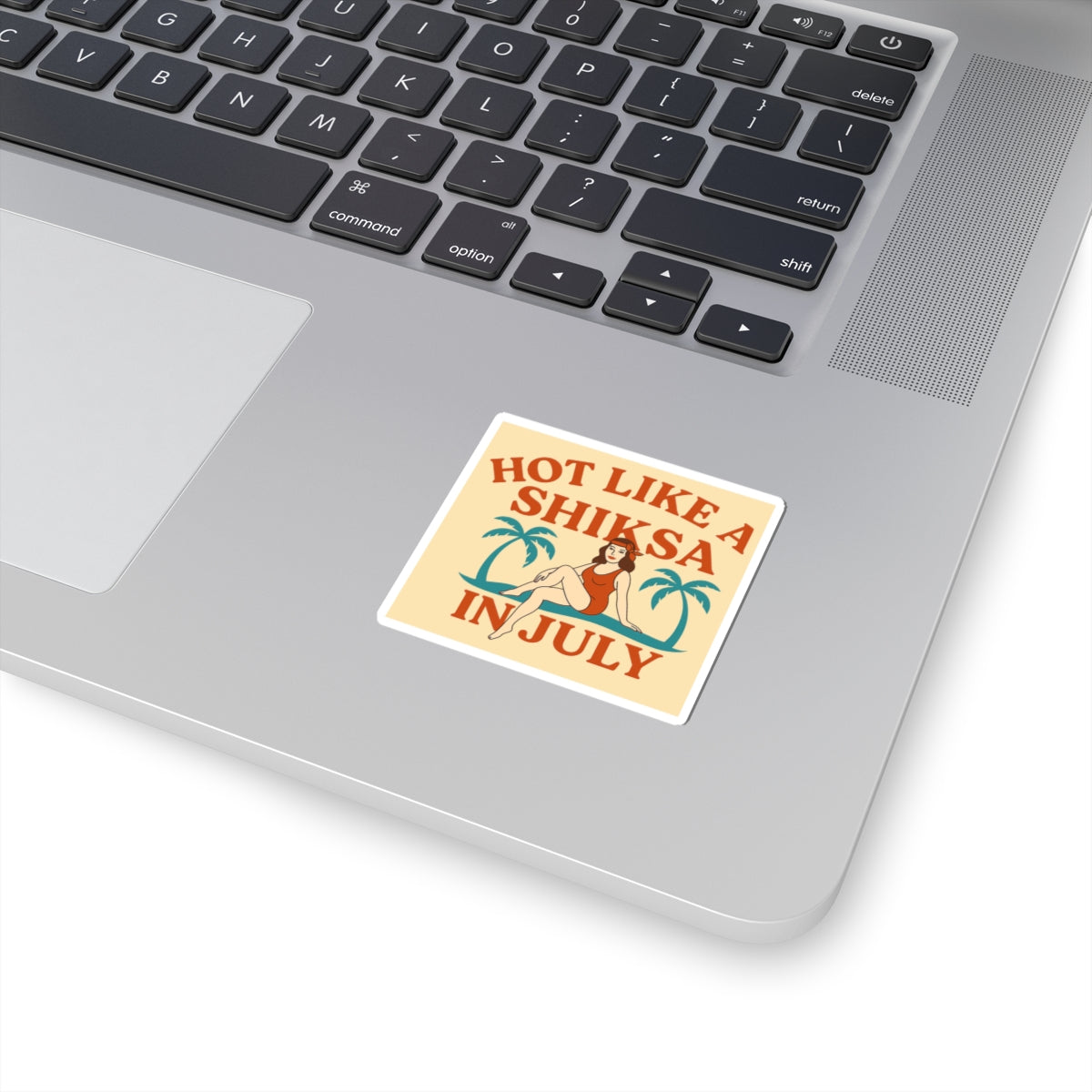 Laptop with a sticker reading 'Hot like a shiksa in July' on the palm rest area.