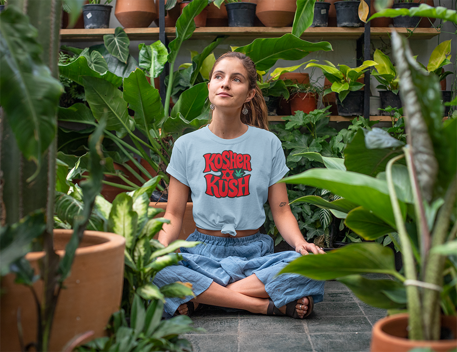 Woman sitting among plants wearing a 'Kosher Kush' t-shirt