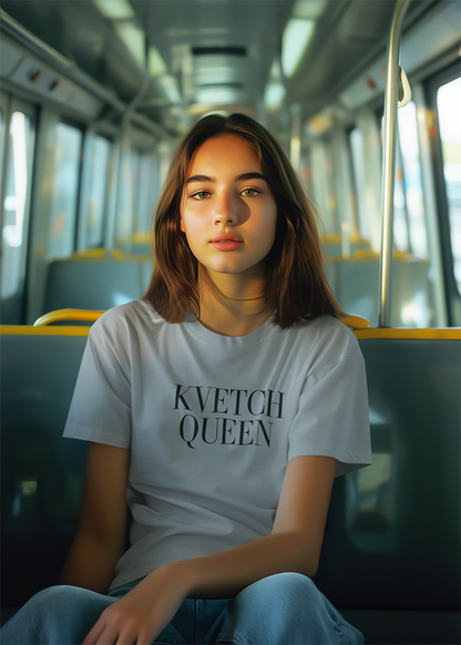 Person wearing a white t-shirt with 'KVETCH QUEEN' text on a bus.