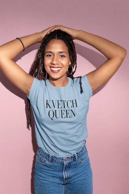 Person wearing a blue t-shirt with 'KVETCH QUEEN' text against a pink background