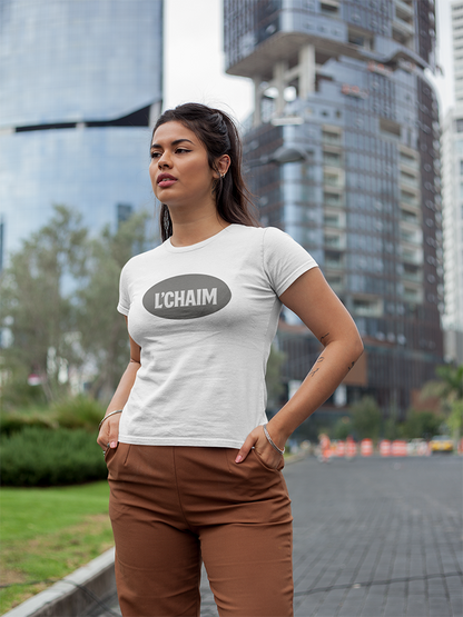 Woman wearing a white t-shirt with 'L'CHAIM' logo in an urban setting