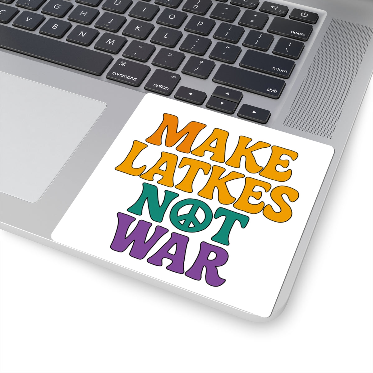 Sticker with 'Make Latkes Not War' text on a laptop keyboard