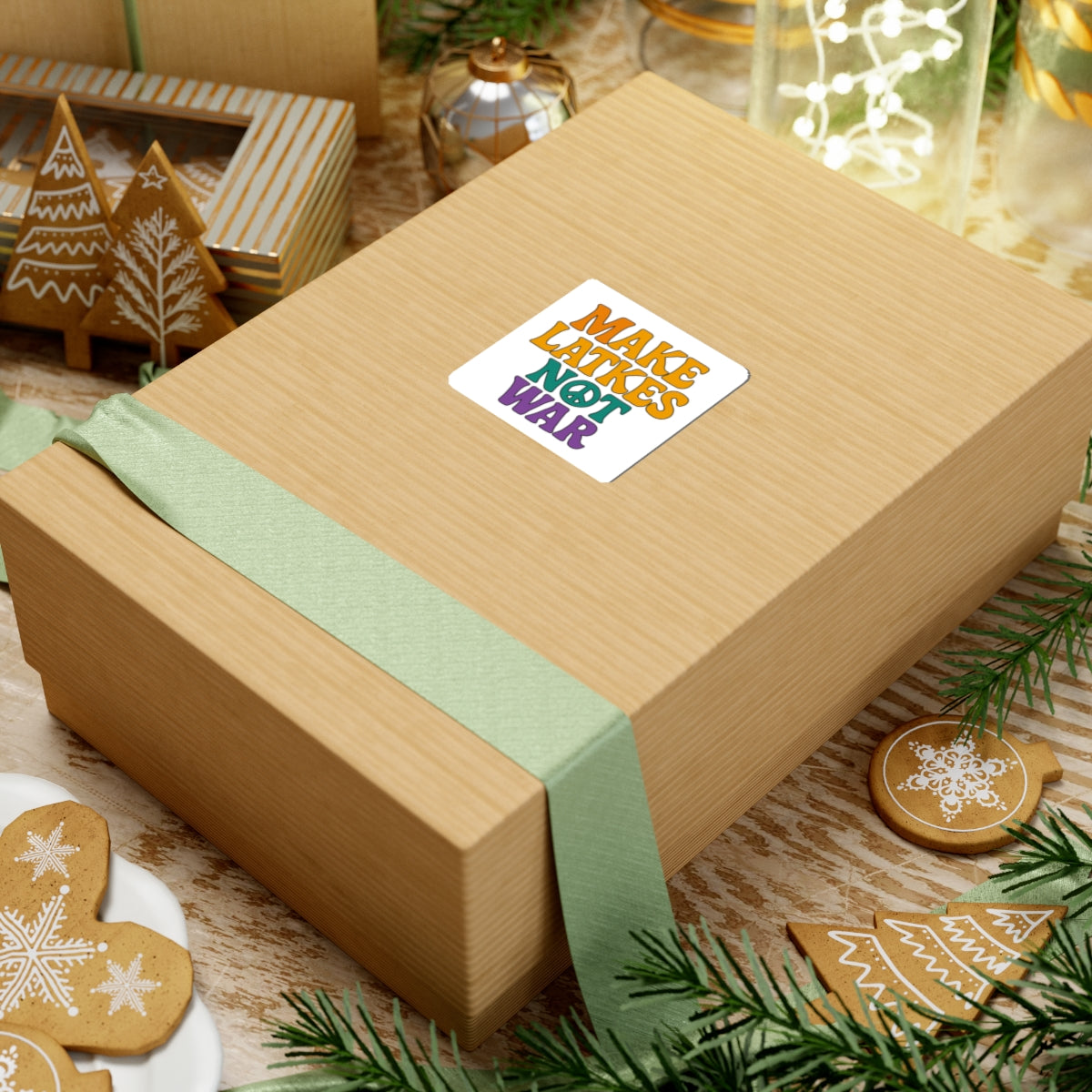 Wooden gift box with a colorful 'make latkes not war' sticker on a festive background with cookies and lights