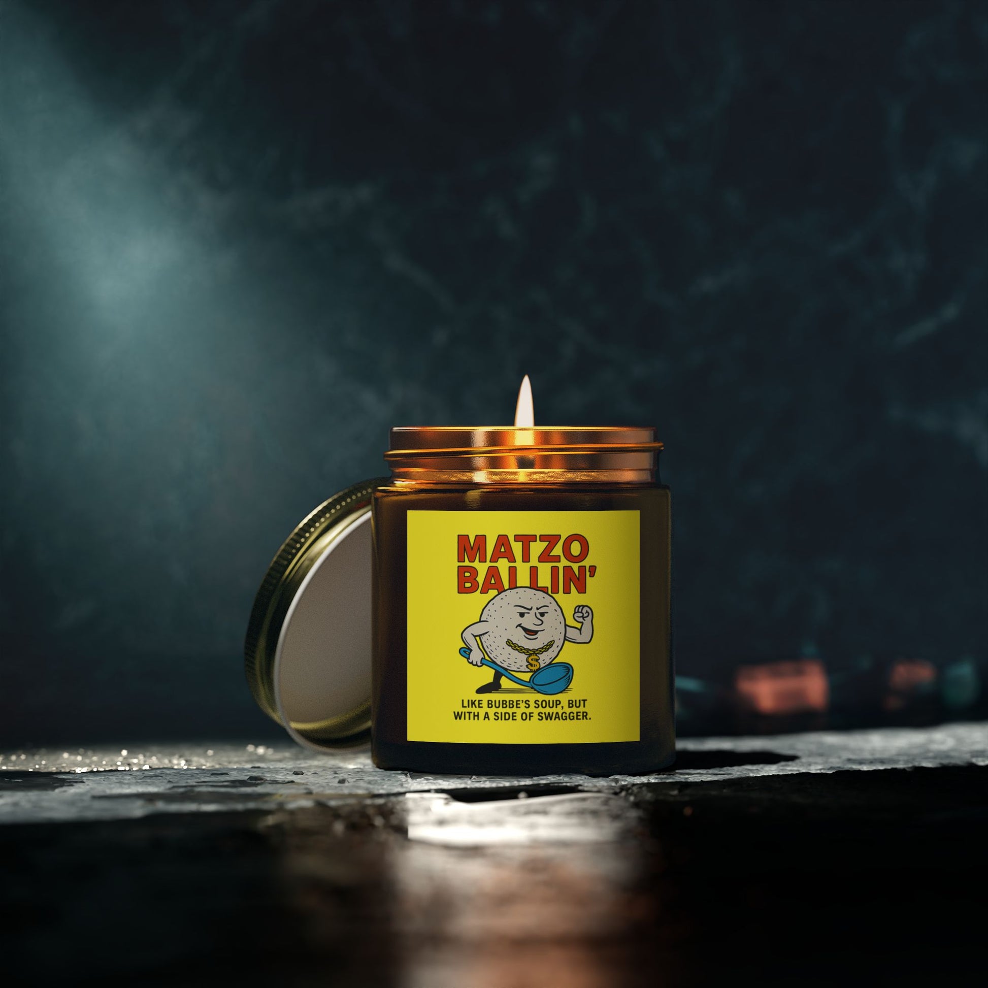 Candle in a jar with 'Matzo Ballin' label on a dark background