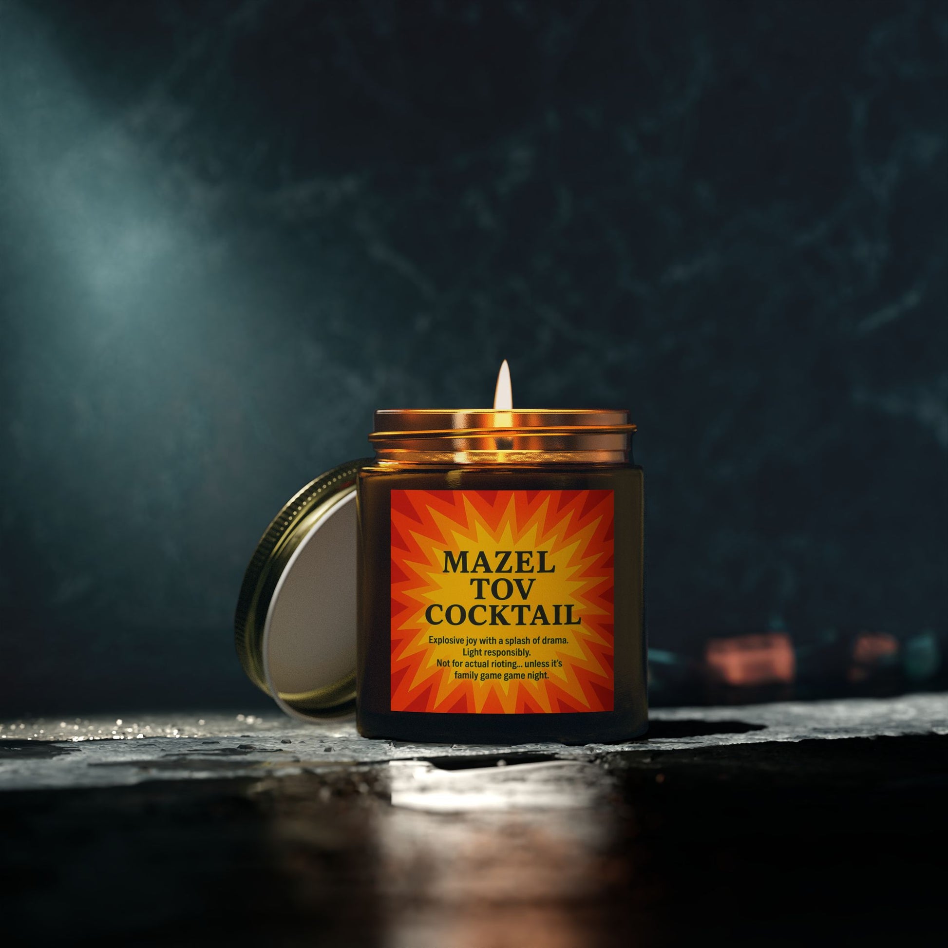 Candle in a jar labeled 'Mazel Tov Cocktail' with a dark background