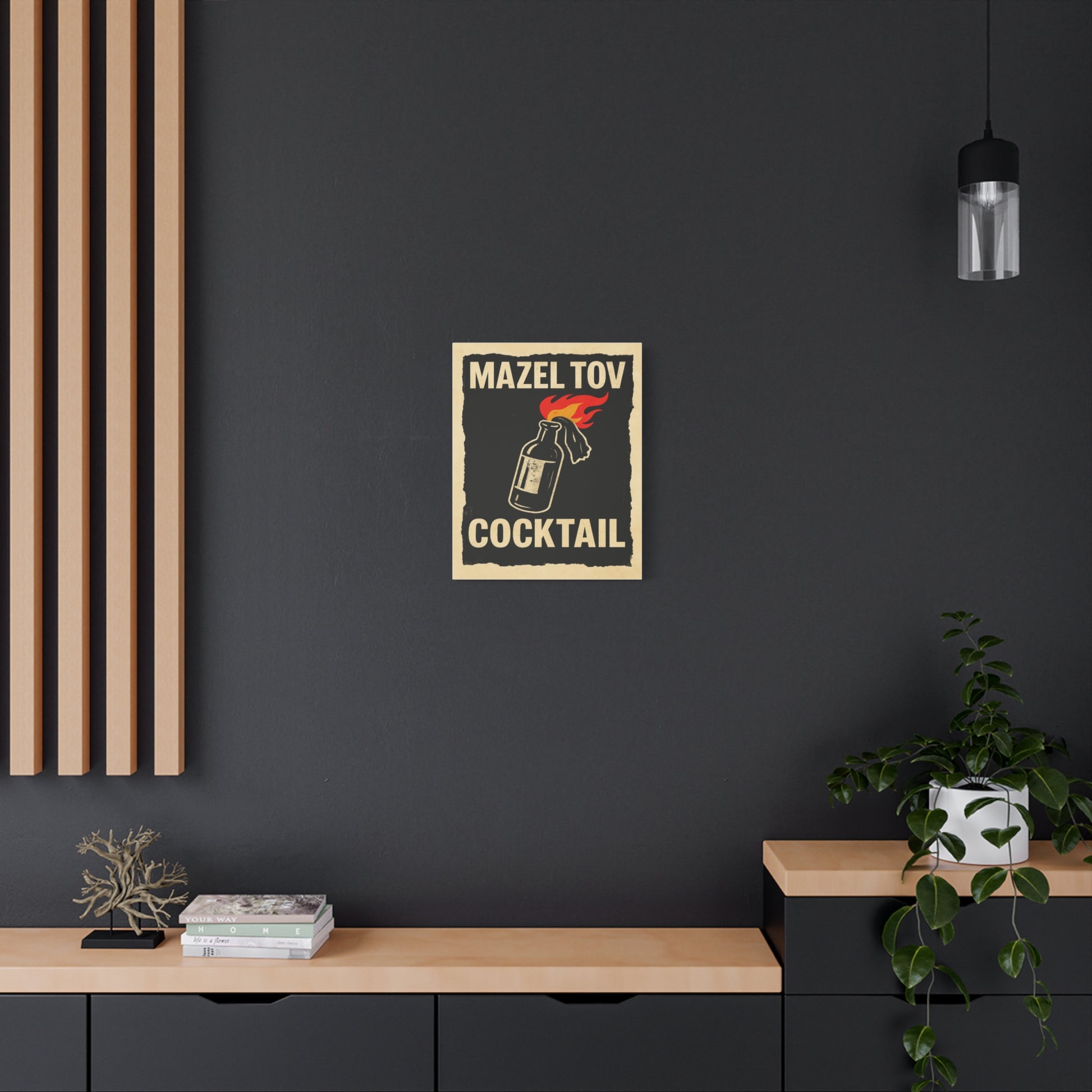 Poster with 'Mazel Tov Cocktail' design on a dark wall above a wooden shelf.