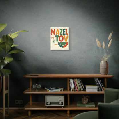 Decorative poster with 'Mazel Tov' text on a wall above a wooden shelf with books and a plant.