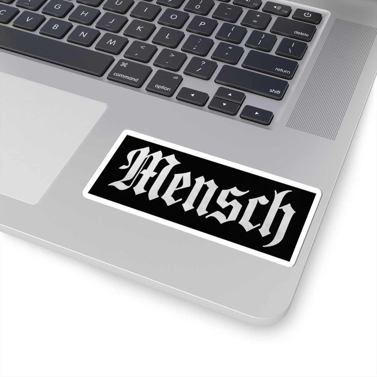 Laptop with a 'Mensch' sticker on the palm rest area