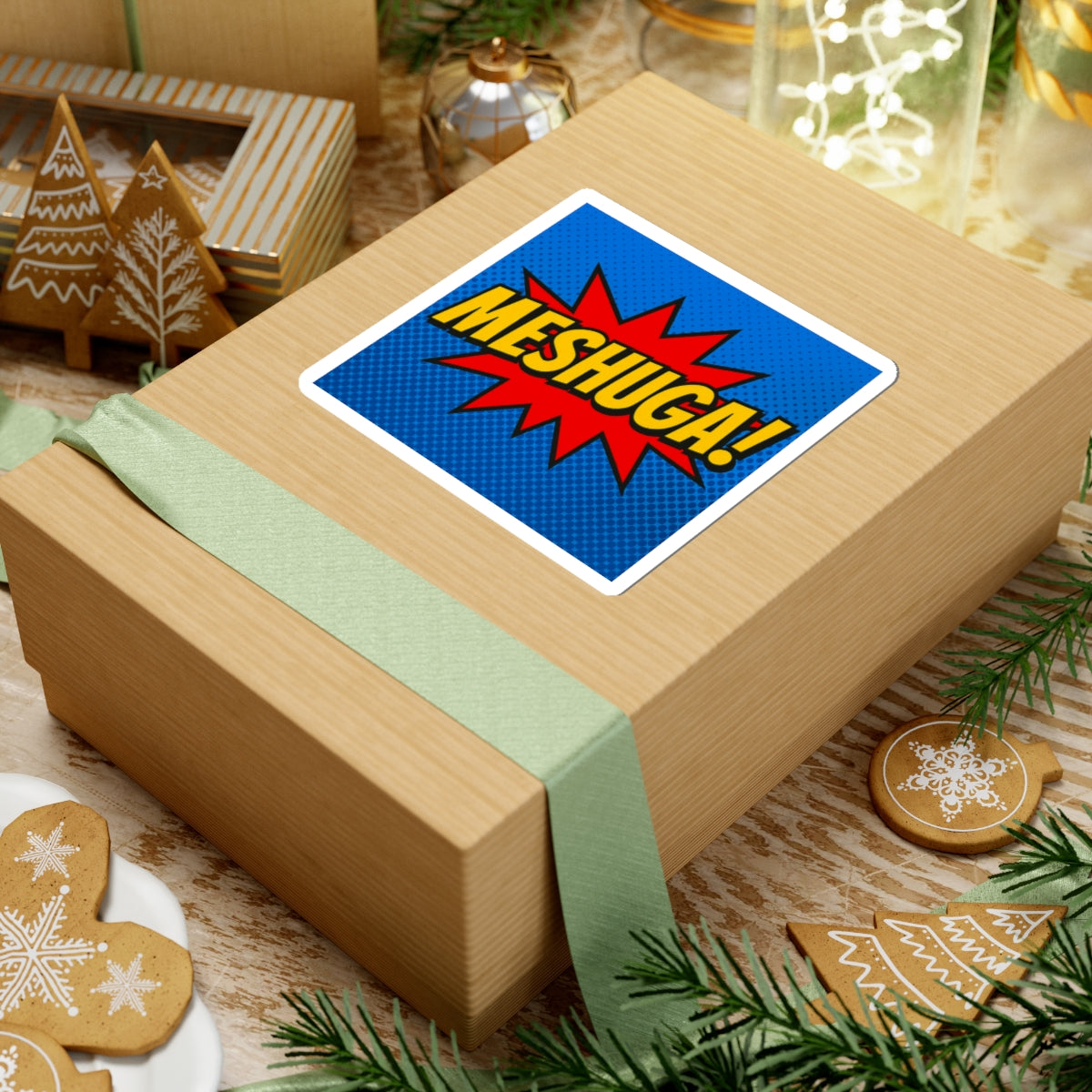 Wooden gift box with a 'Meshugah!' sticker on a festive background with cookies and lights.