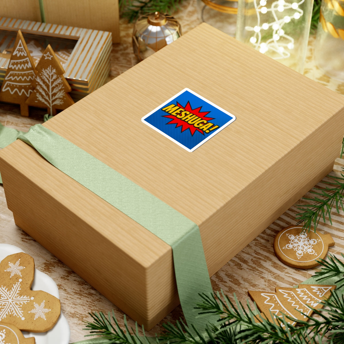 Wooden gift box with a green ribbon and a colorful meshuga on a festive background with cookies and lights.